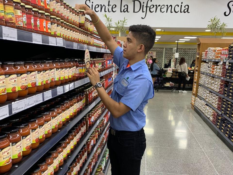 Mercaderista organizando un anaquel en un supermercado
